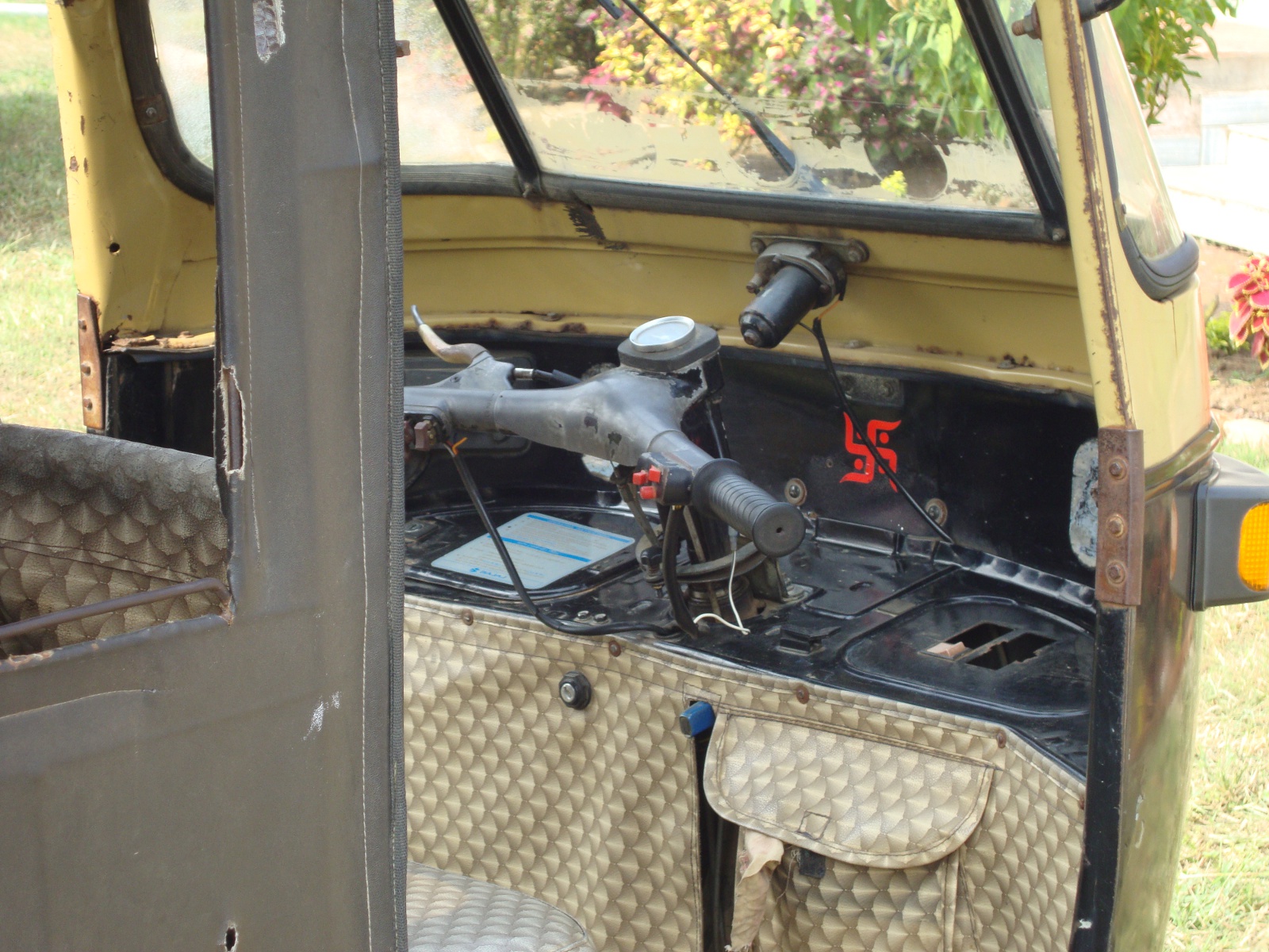 Interior of an auto-rickshaw, showing its scooter-style handlebars.