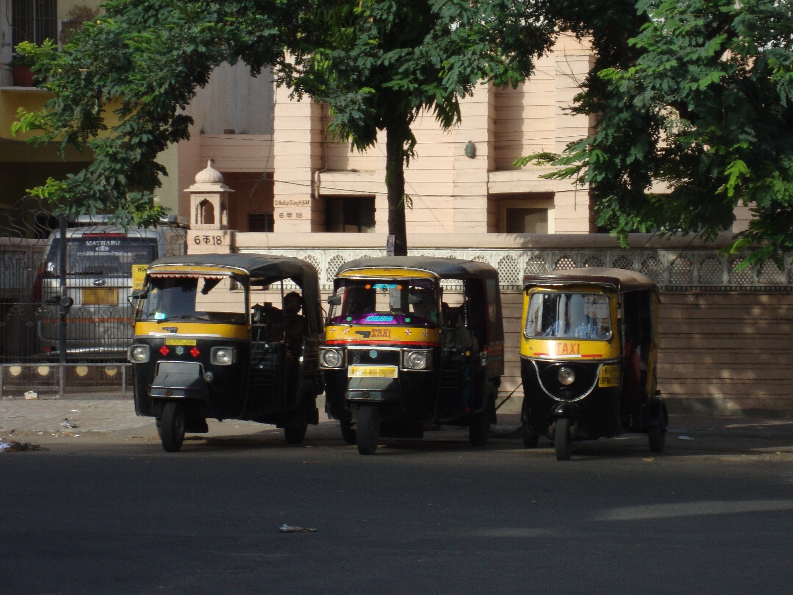 Different types of rickshaws on a street in Jaipur.