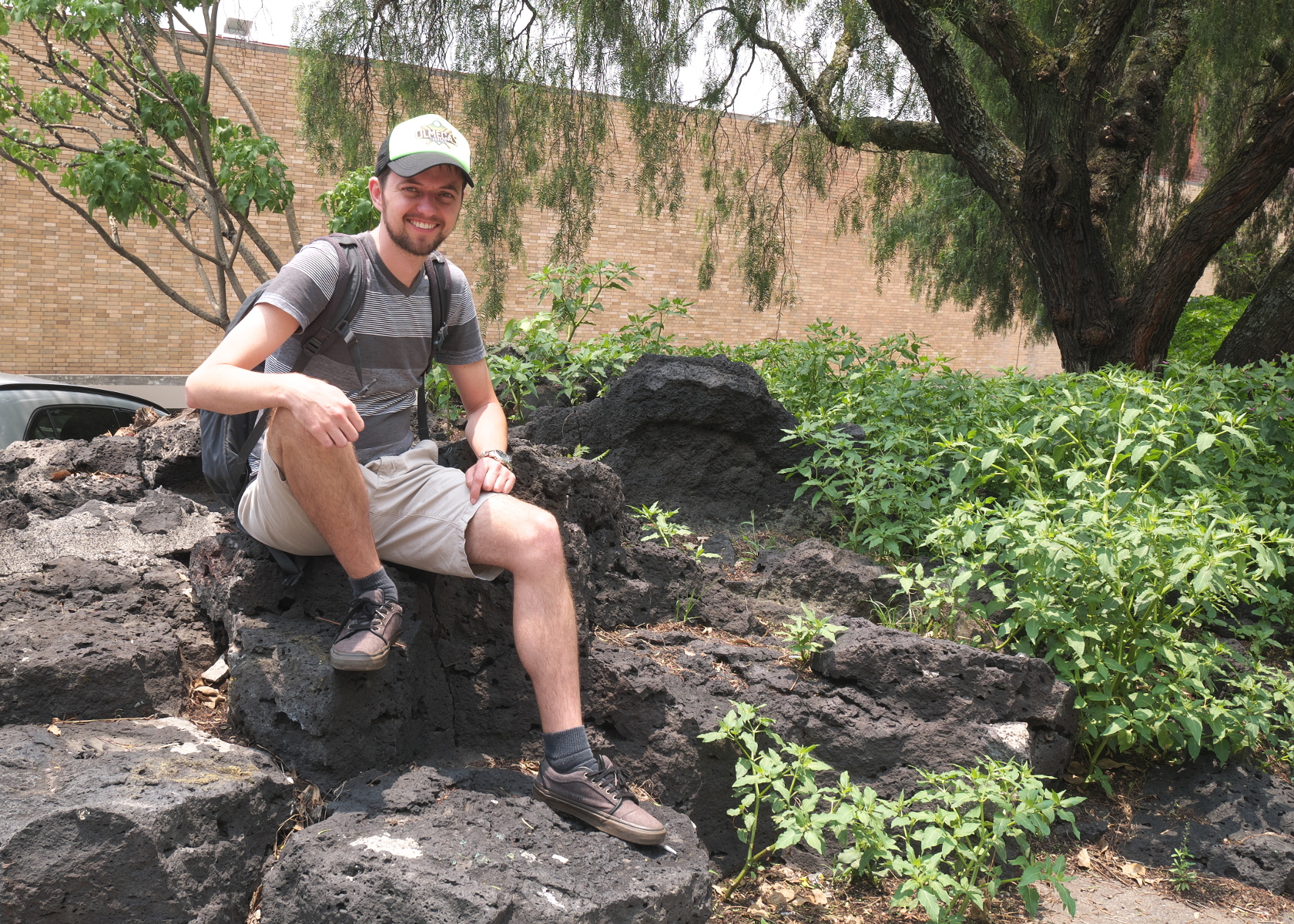 Your blogger sitting on a surviving piece of the Pedregal on the UNAM campus. (Photo by Verónica Trinidad Gallegos.)